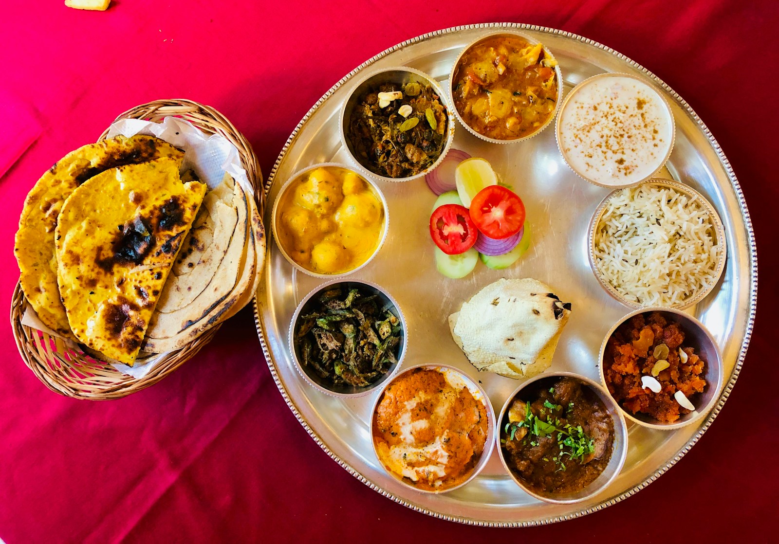 A vegetarian Indian thali — dal, sabzi, rice, roti and raita on a steel platter