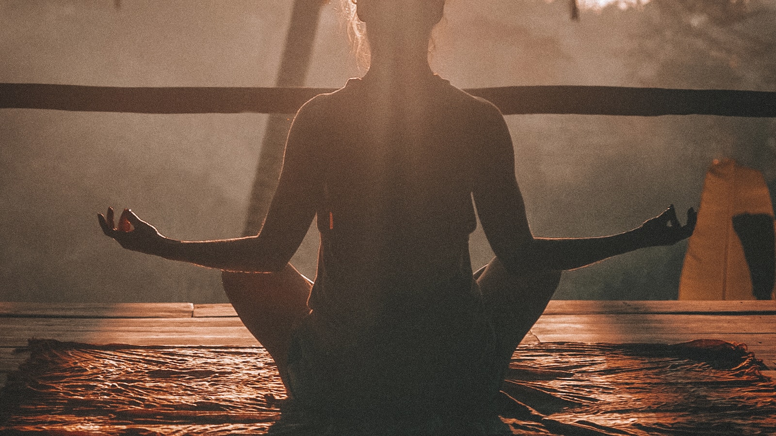 A figure seated in meditation in warm morning light